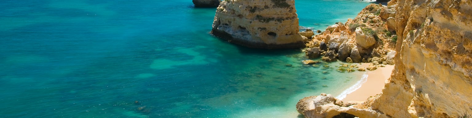Rocks and a white, sandy beach in Marinha Cove, Portugal