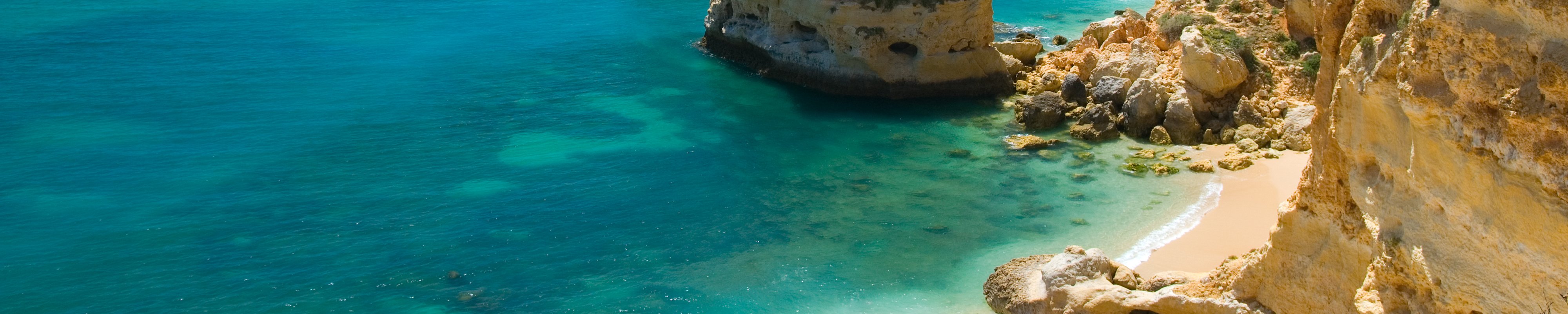 Rocks and a white, sandy beach in Marinha Cove, Portugal