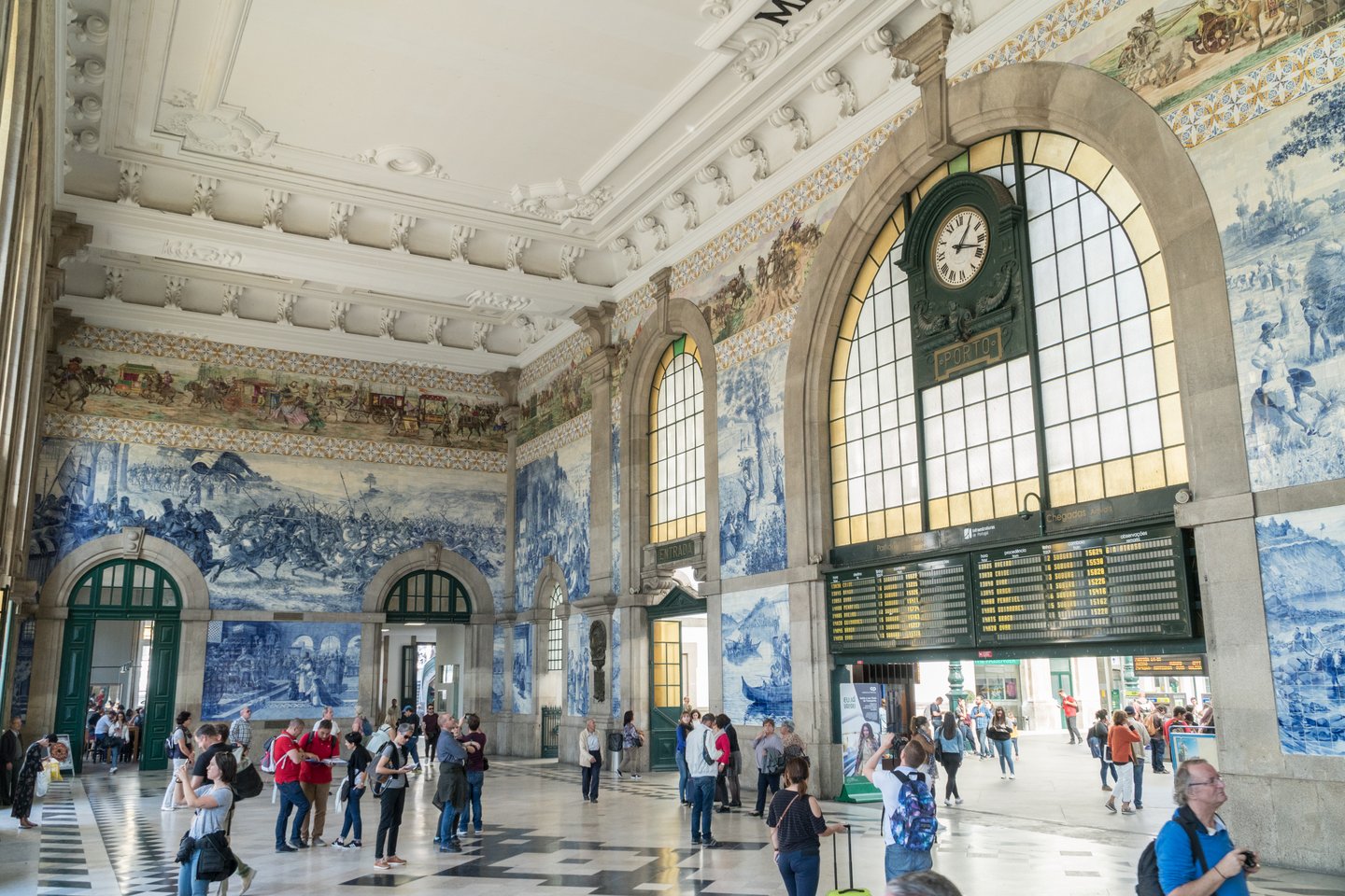 People in the vestibule of Sao Bento Railway Station, decorated with approximately 20,000 azulejo tiles, in Porto, Portugal 