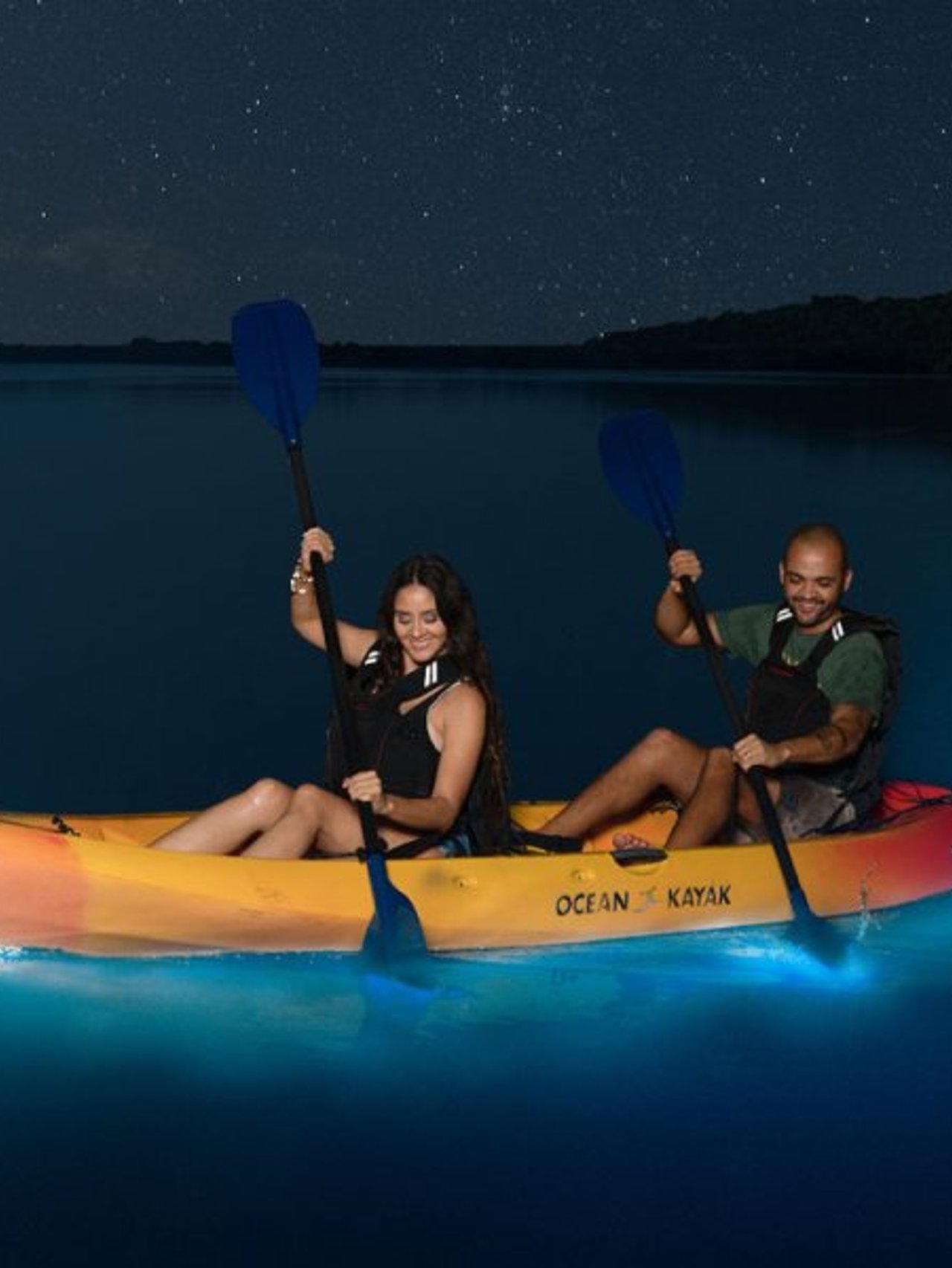 A couple kayaking at Luguna Grande with bioluminescence in the water