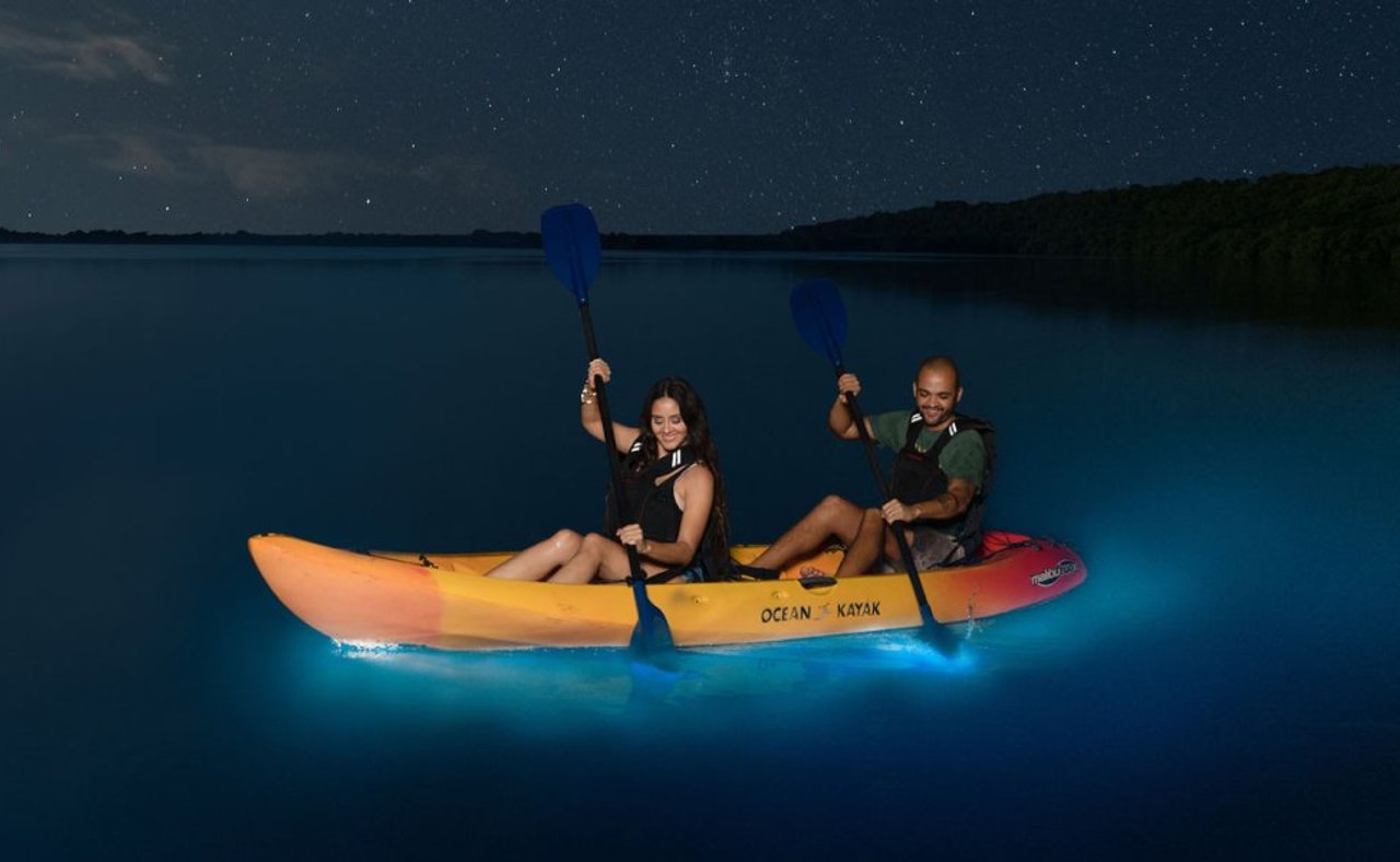 A couple kayaking at Luguna Grande with bioluminescence in the water