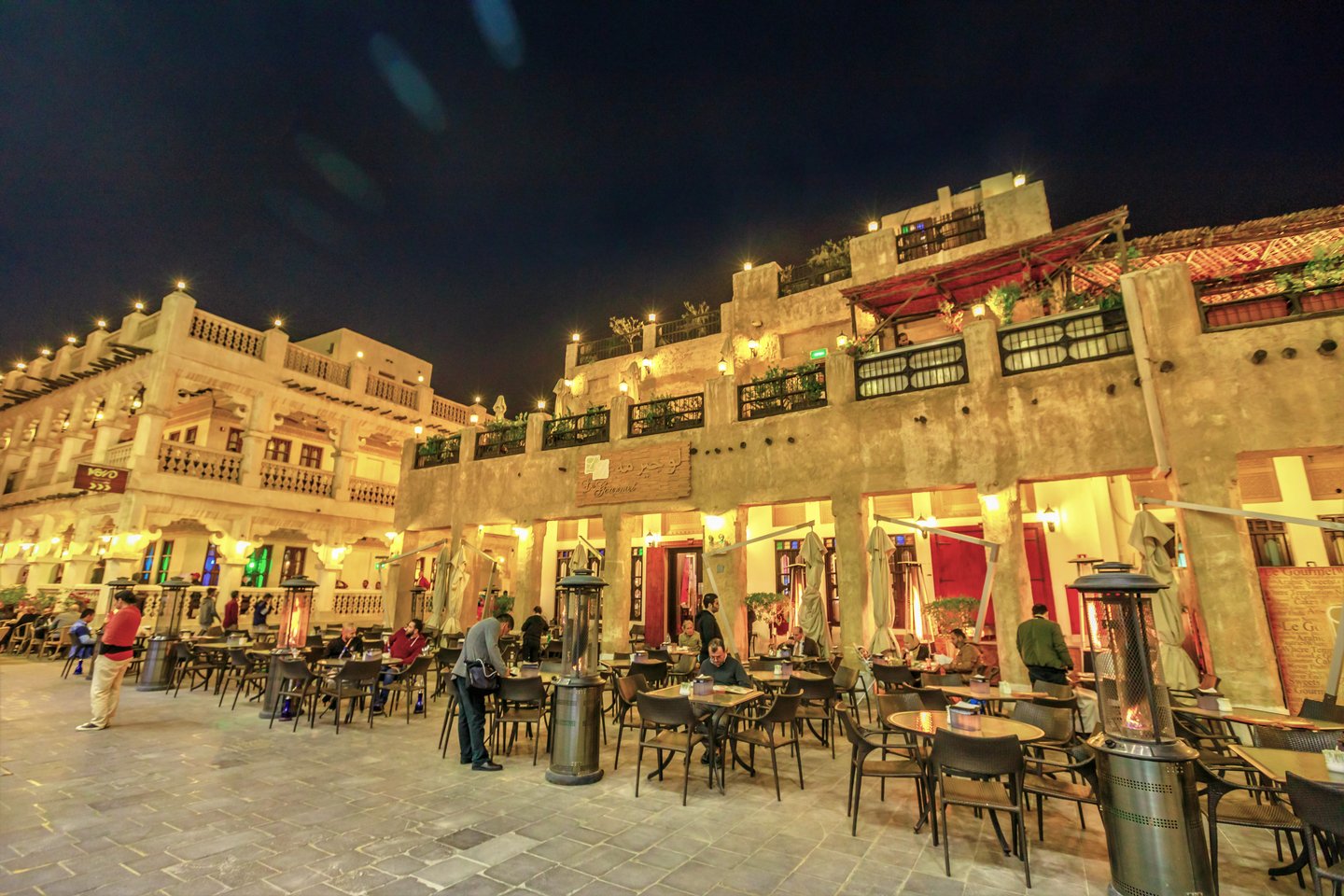 People eating at restaurants at Souq Waqib at night