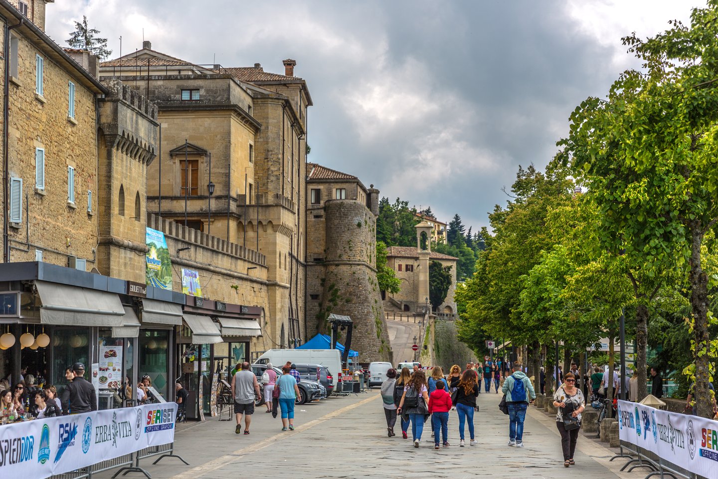 People walking in San Marino's old town on a cloudy day.