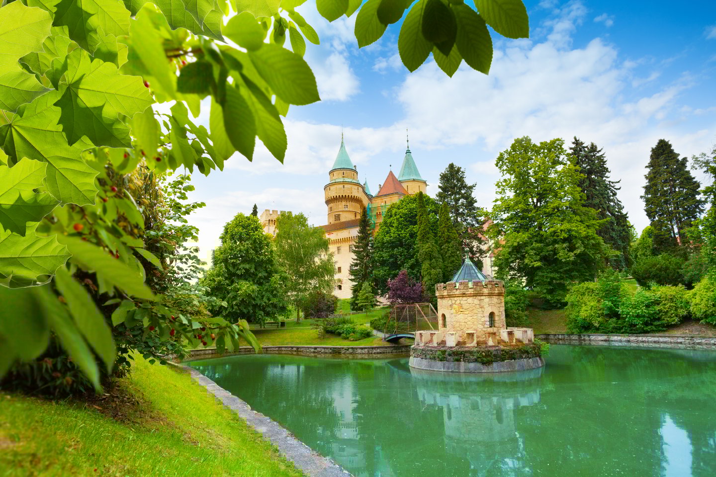 A view of Bojnice Castle over the water from the park