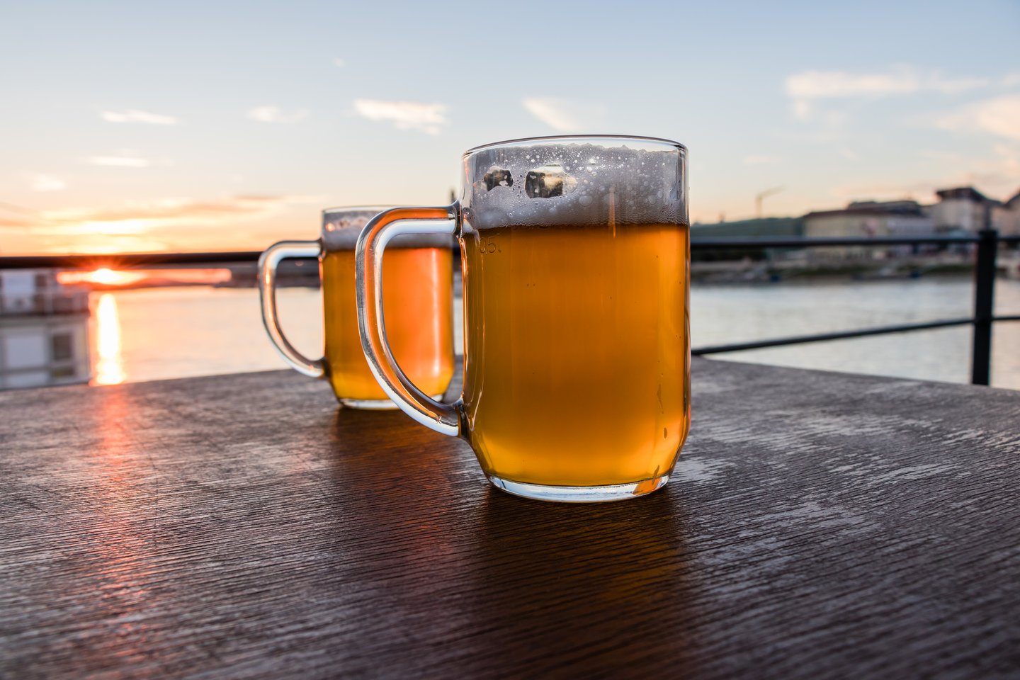 Two mugs of beer on a wooden table in Bratislava, Slovakia