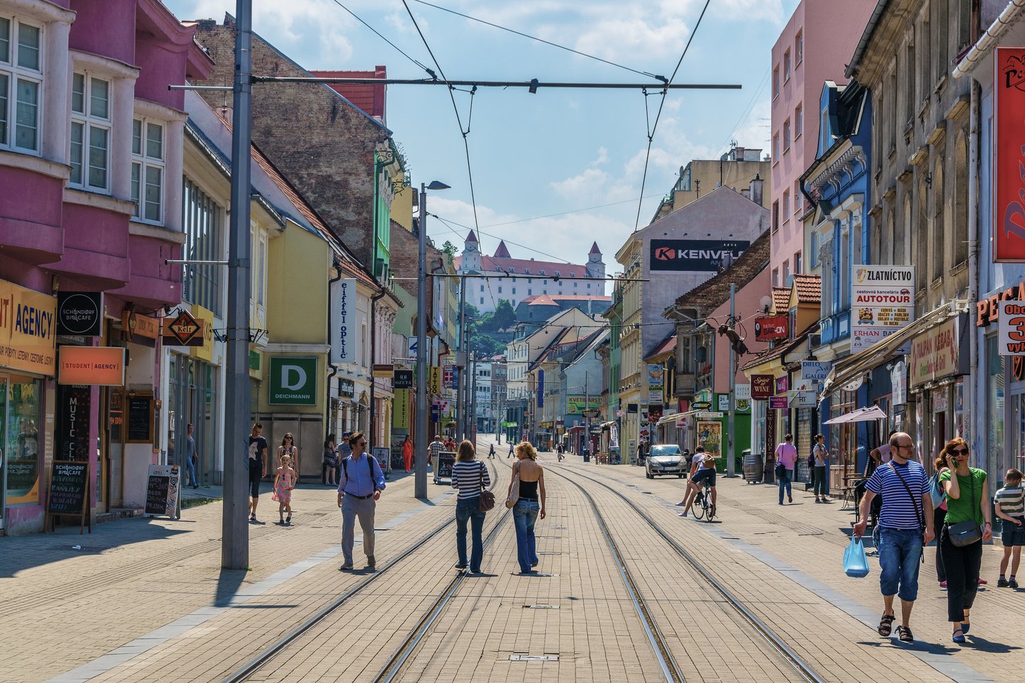 People walking along the tramlines in a wide street in Bratislava, Slovakia