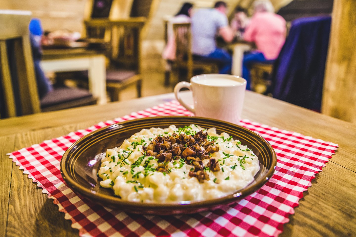 A plate of bryndzove halusky with a cup of žinčica (sour milk) 