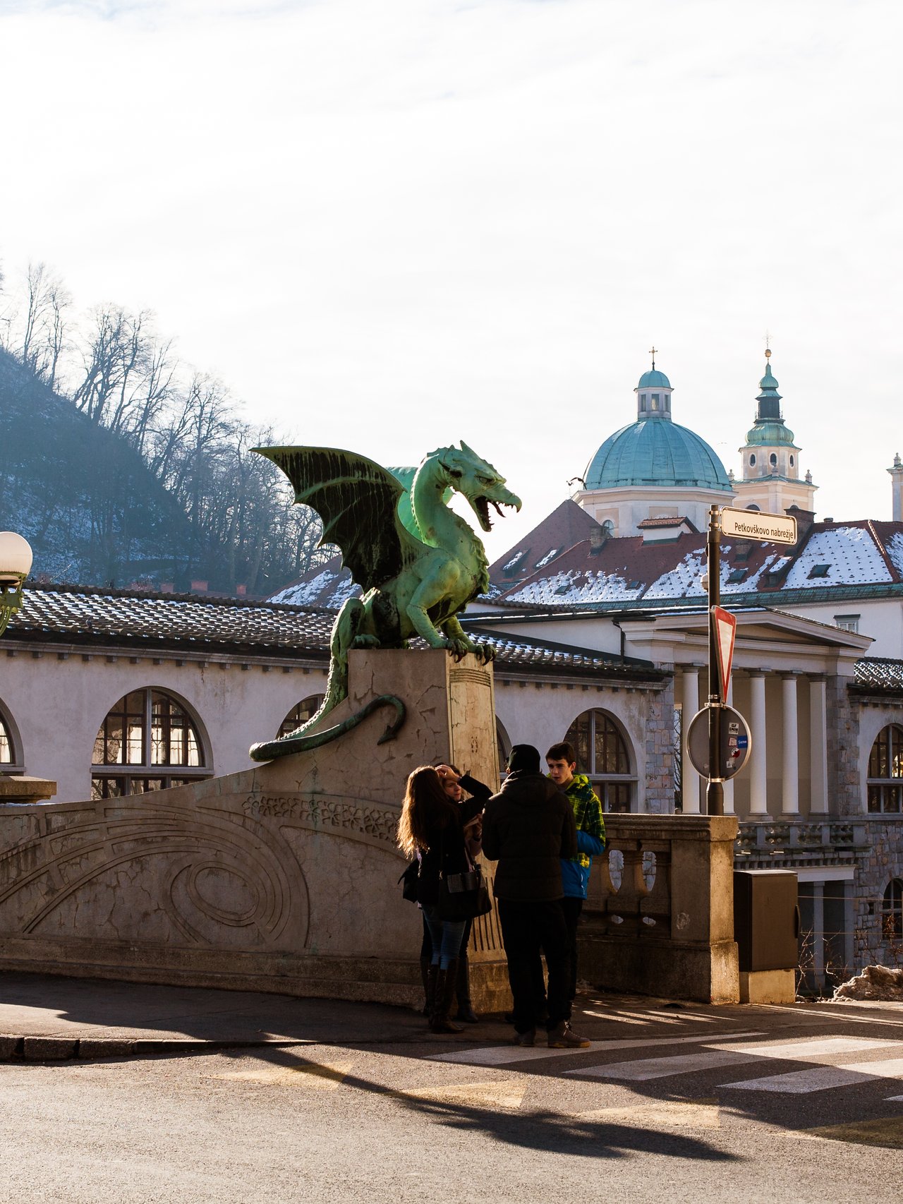 Dragon Bridge in Ljubljana, Slovenia with some people taking photos near the dragon