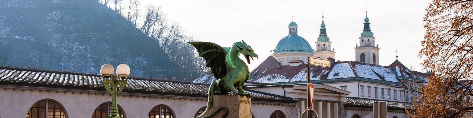 Dragon Bridge in Ljubljana, Slovenia with some people taking photos near the dragon