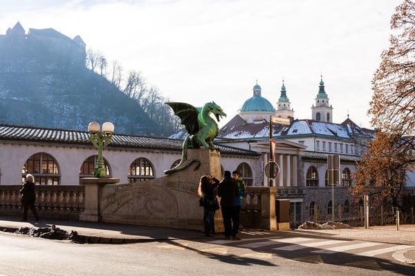 Dragon Bridge in Ljubljana, Slovenia with some people taking photos near the dragon