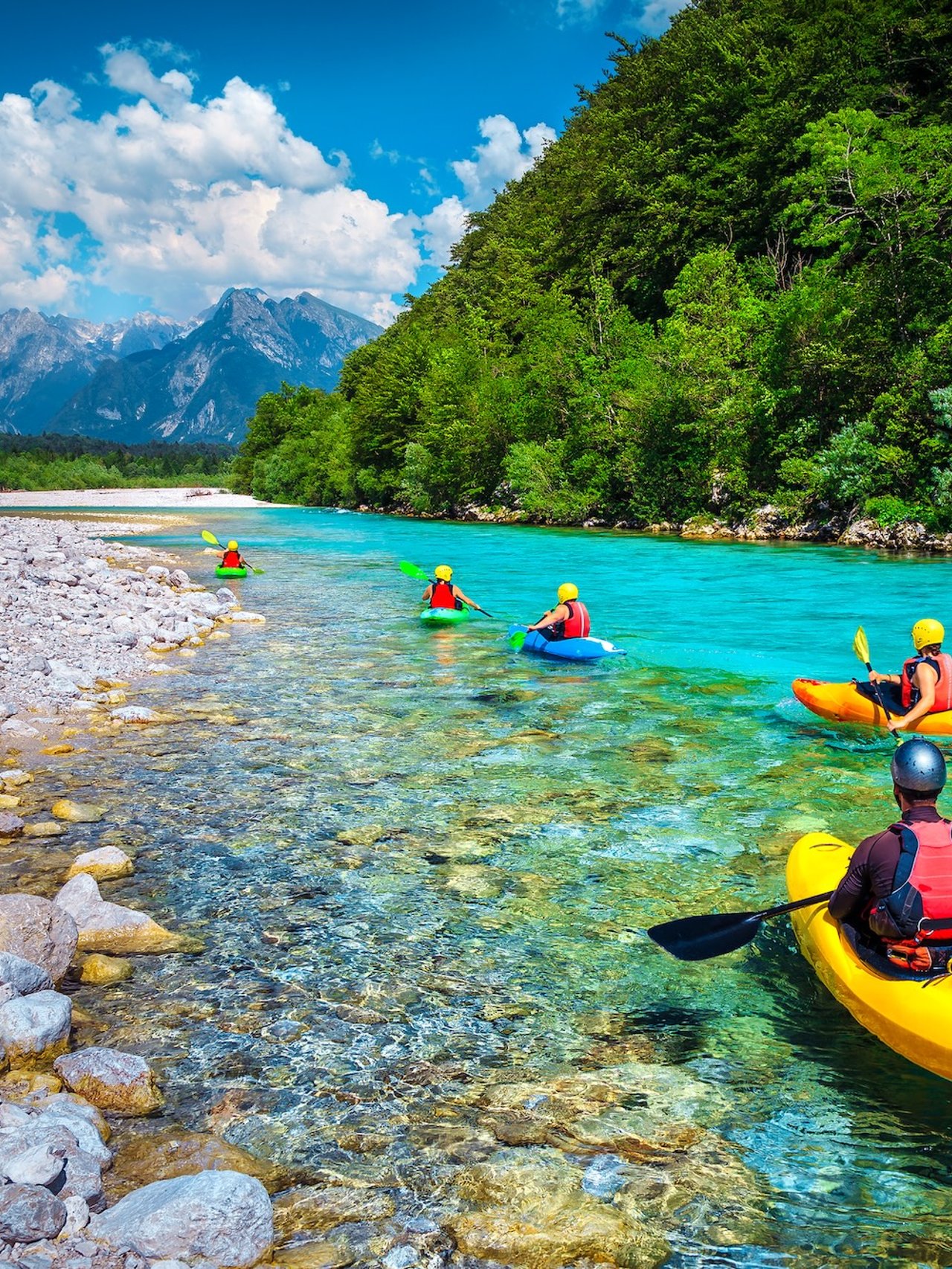 Kayaking down the pristine blue waters of the Soca River in Slovenia