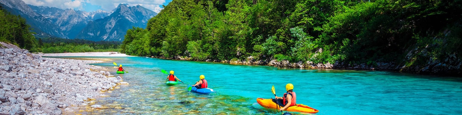 Kayaking down the pristine blue waters of the Soca River in Slovenia