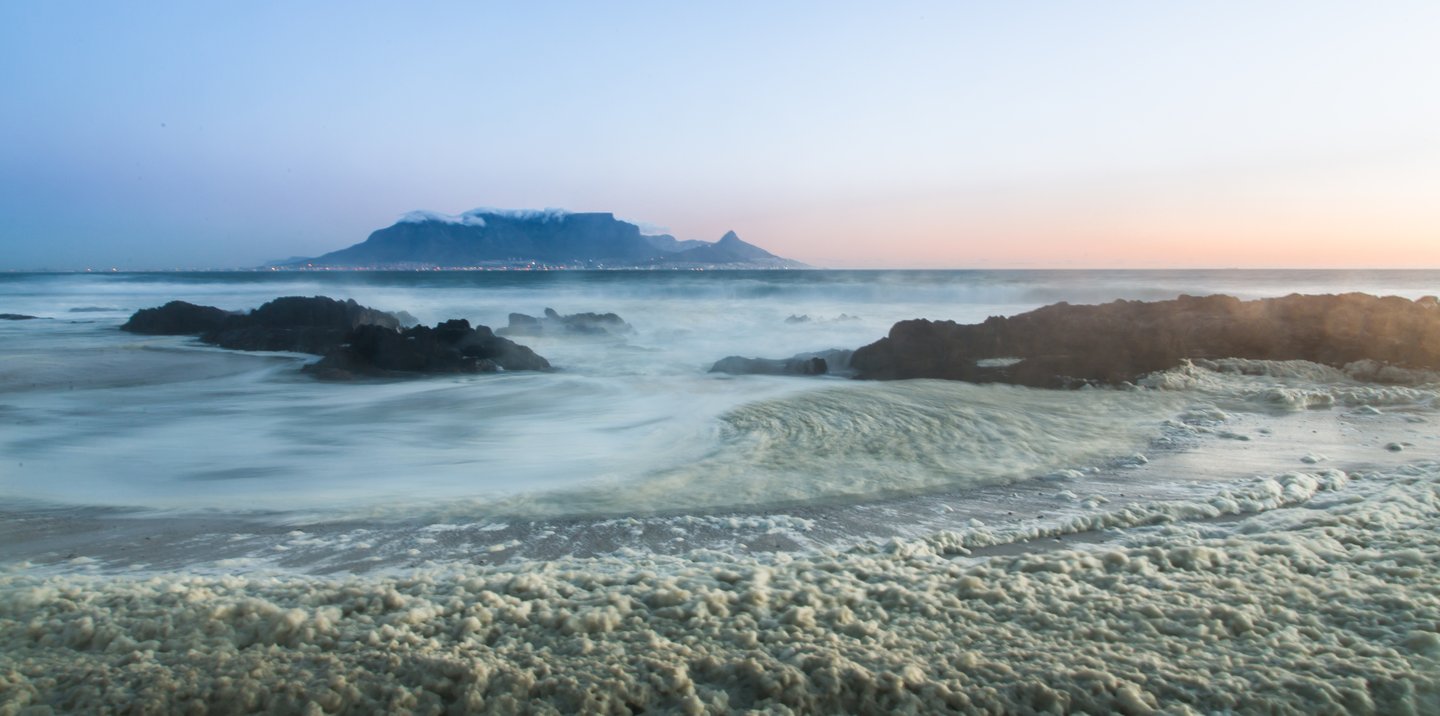 Rough seas in Cape Town with Table Mountain partially obscured by clouds