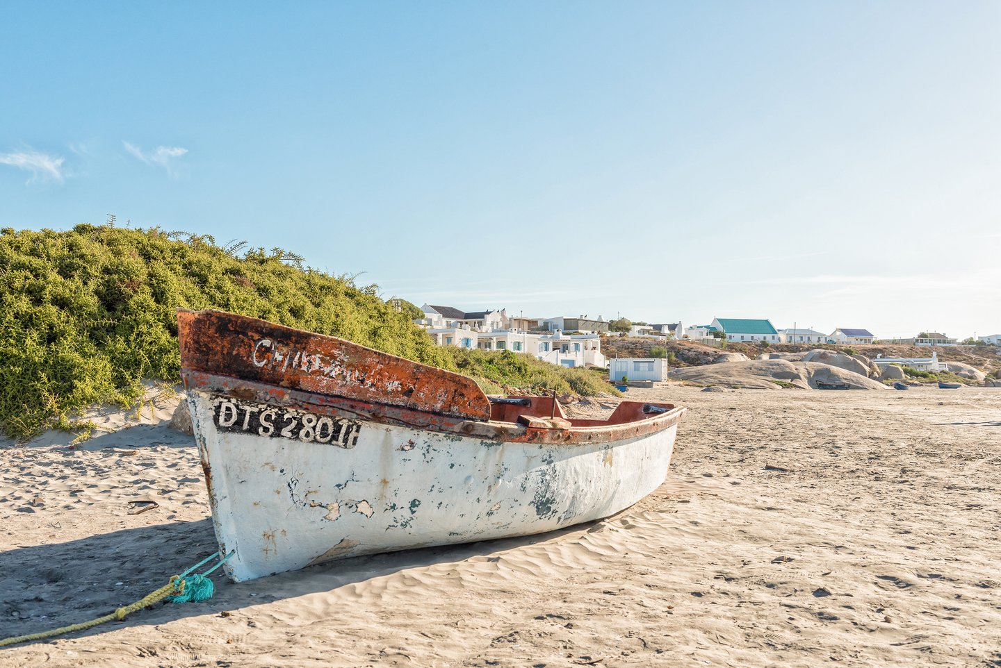 A weathered boat on a sandy beach in Paternoster, South Africa.
