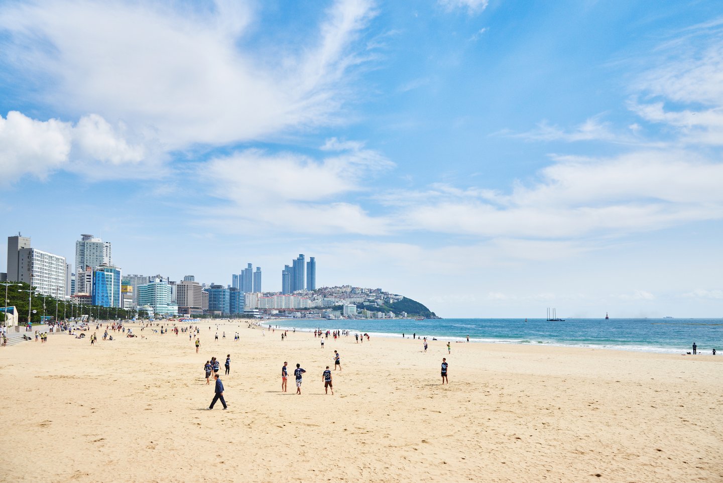 People walking on Haeundae Beach in Busan on a sunny day