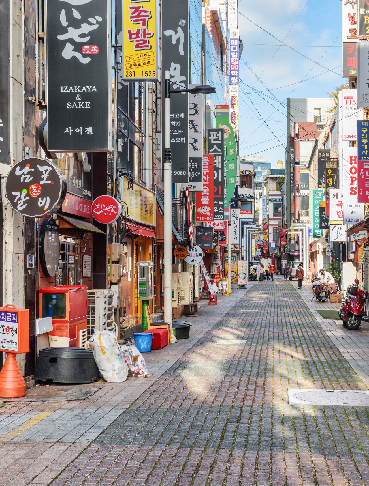 Signs and motorcycles in a quiet street in Busan, South Korea.