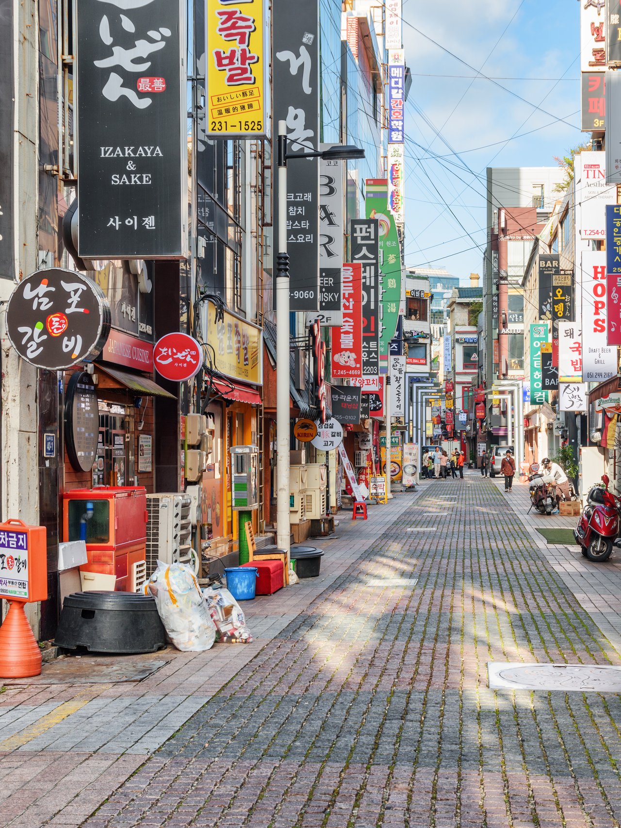 Signs and motorcycles in a quiet street in Busan, South Korea.