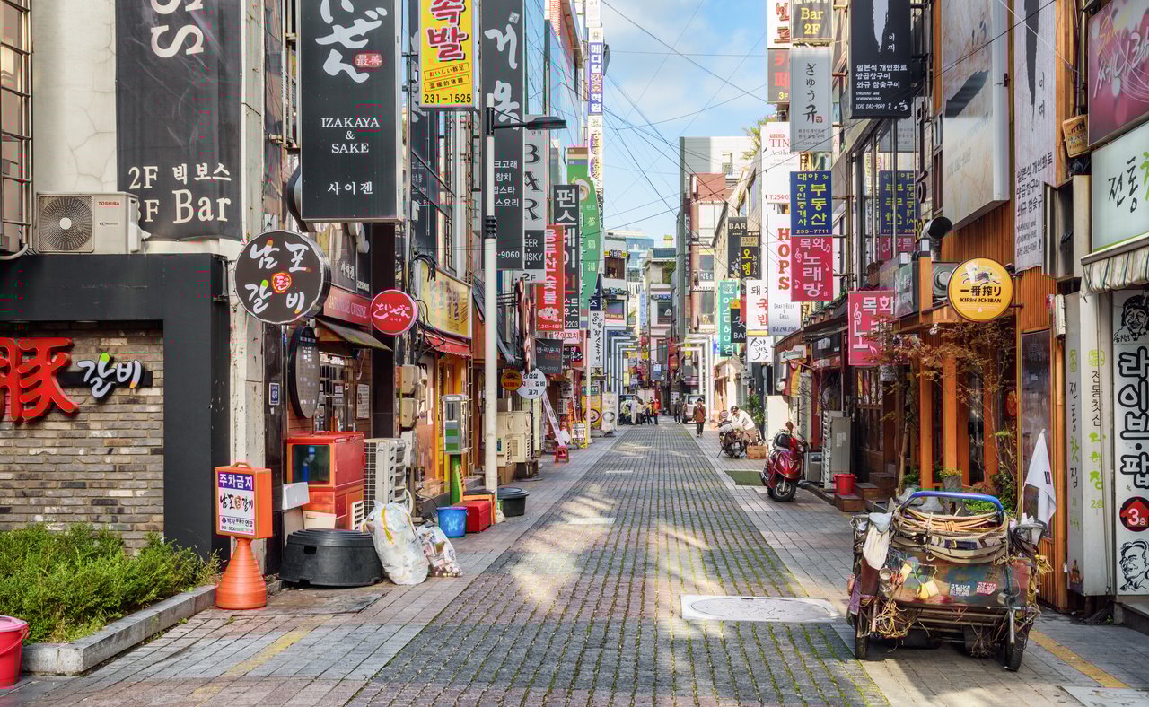 Signs and motorcycles in a quiet street in Busan, South Korea.