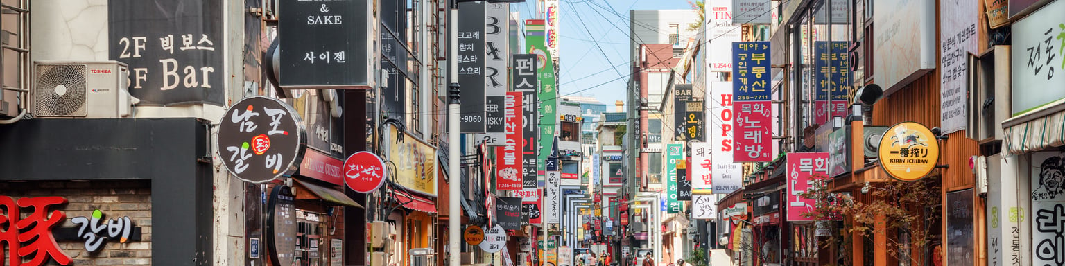 Signs and motorcycles in a quiet street in Busan, South Korea.