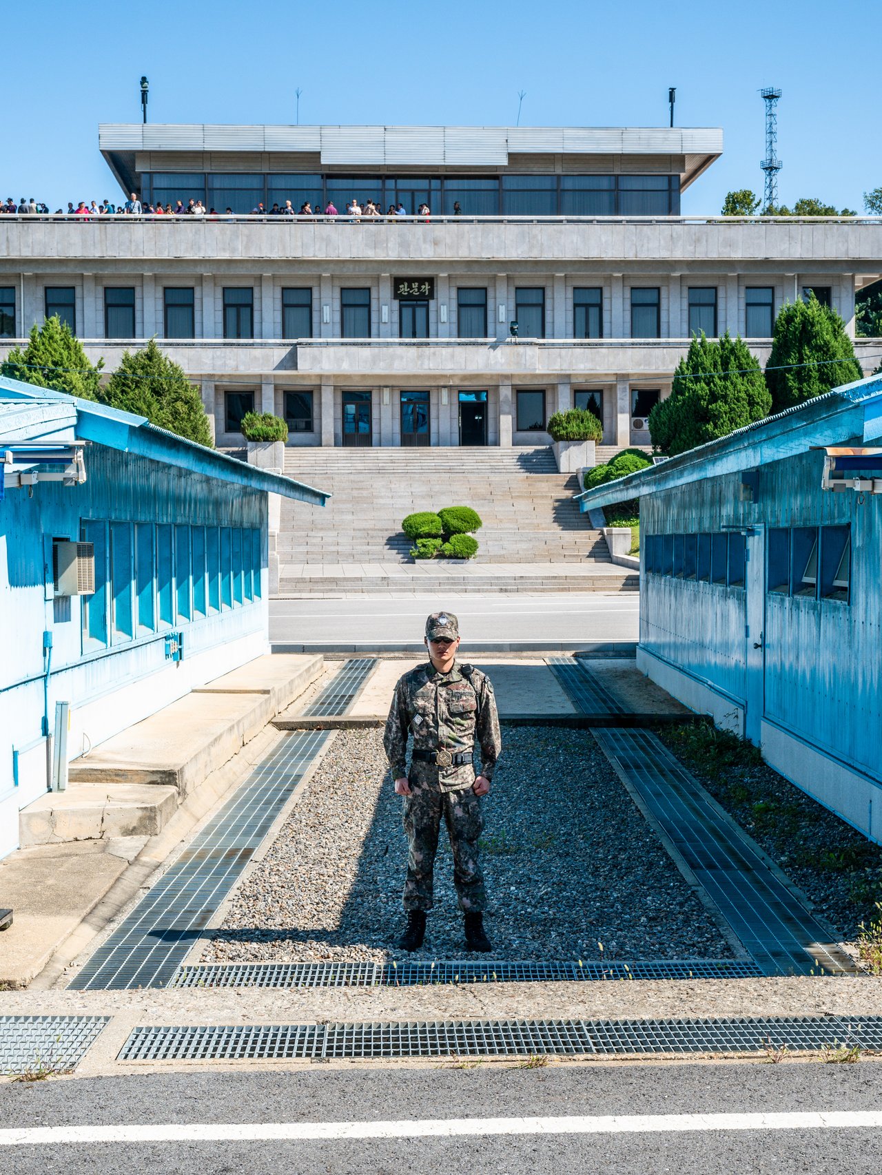 A soldier standing between the blue buildings at the Joint Security Area in Korea