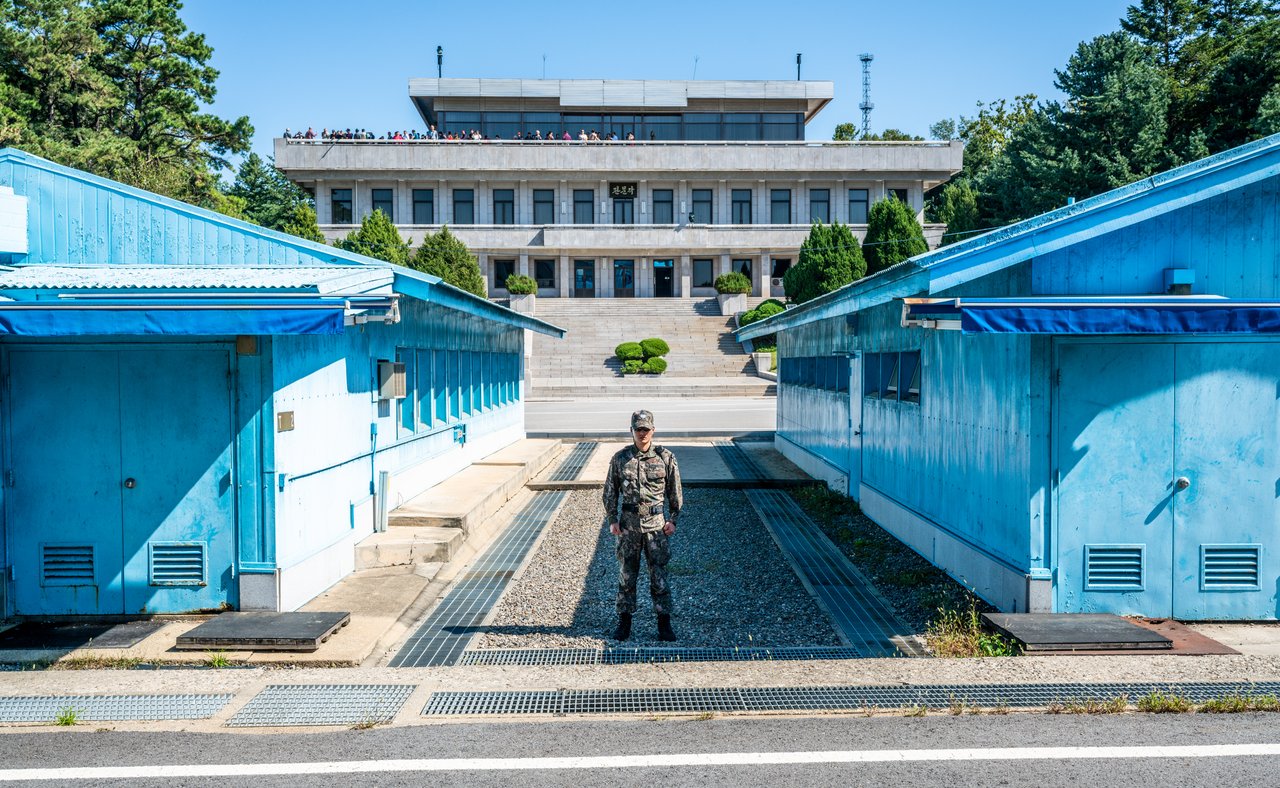 A soldier standing between the blue buildings at the Joint Security Area in Korea