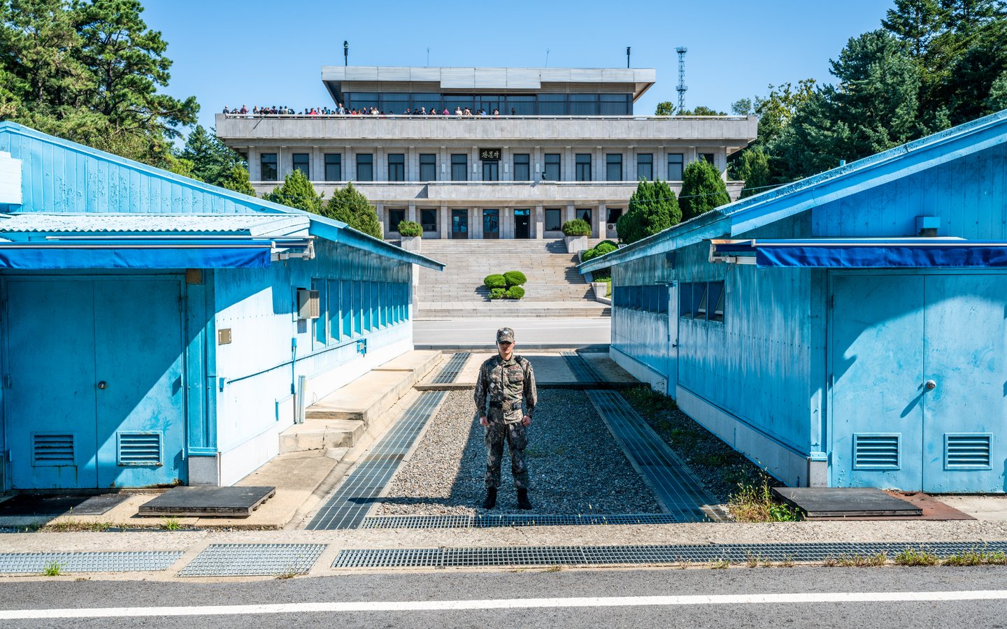 A soldier standing between the blue buildings at the Joint Security Area in Korea