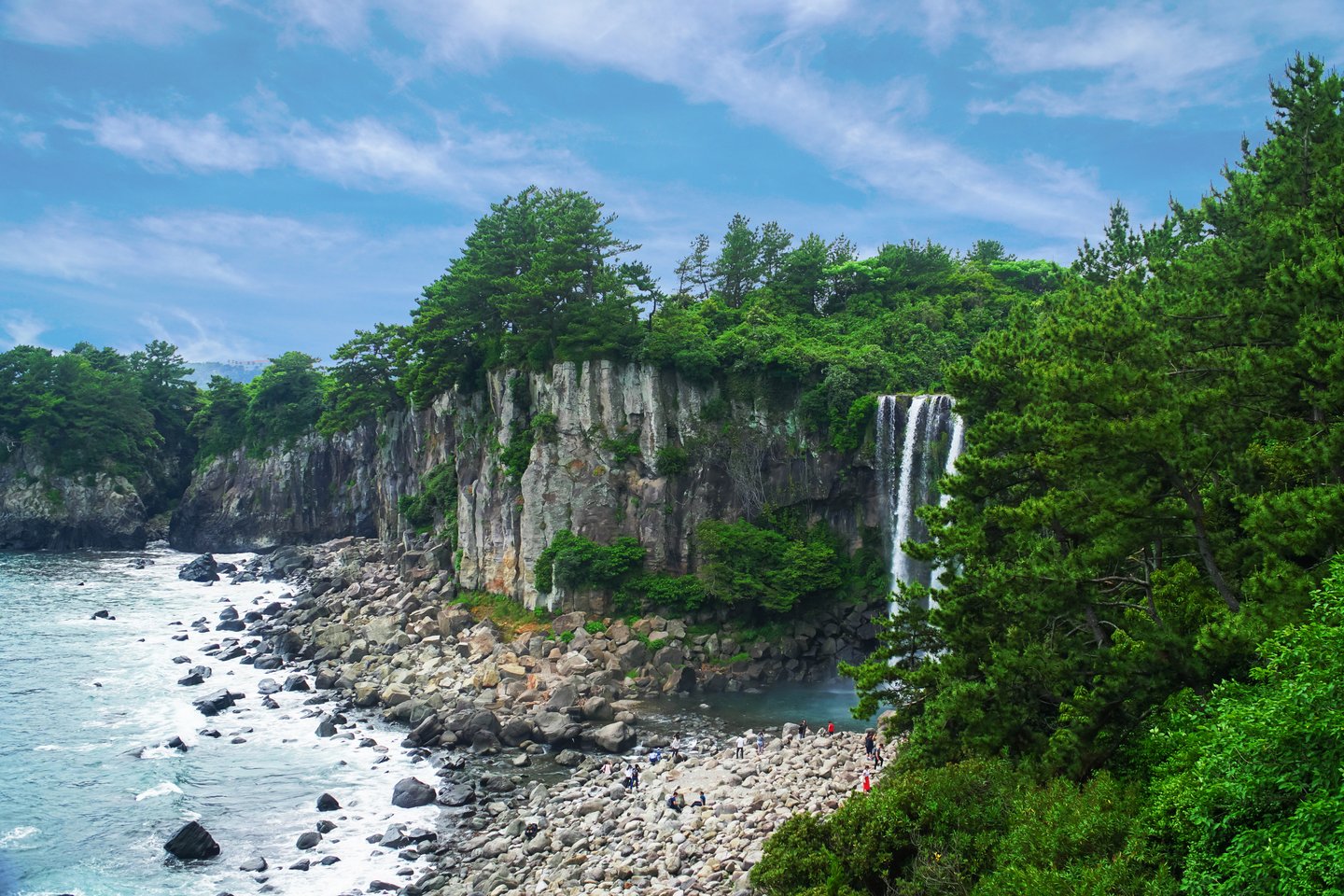 Jeongbang Waterfall surrounded by trees on Jeju Island, South Korea