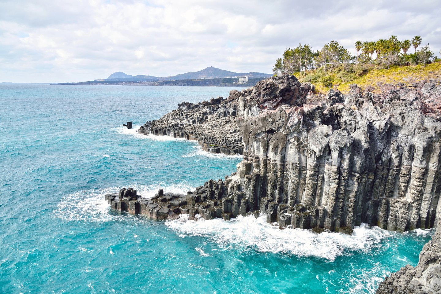 The rough waters and rugged Jusangjeolli Cliff in Jeju Island, South Korea.