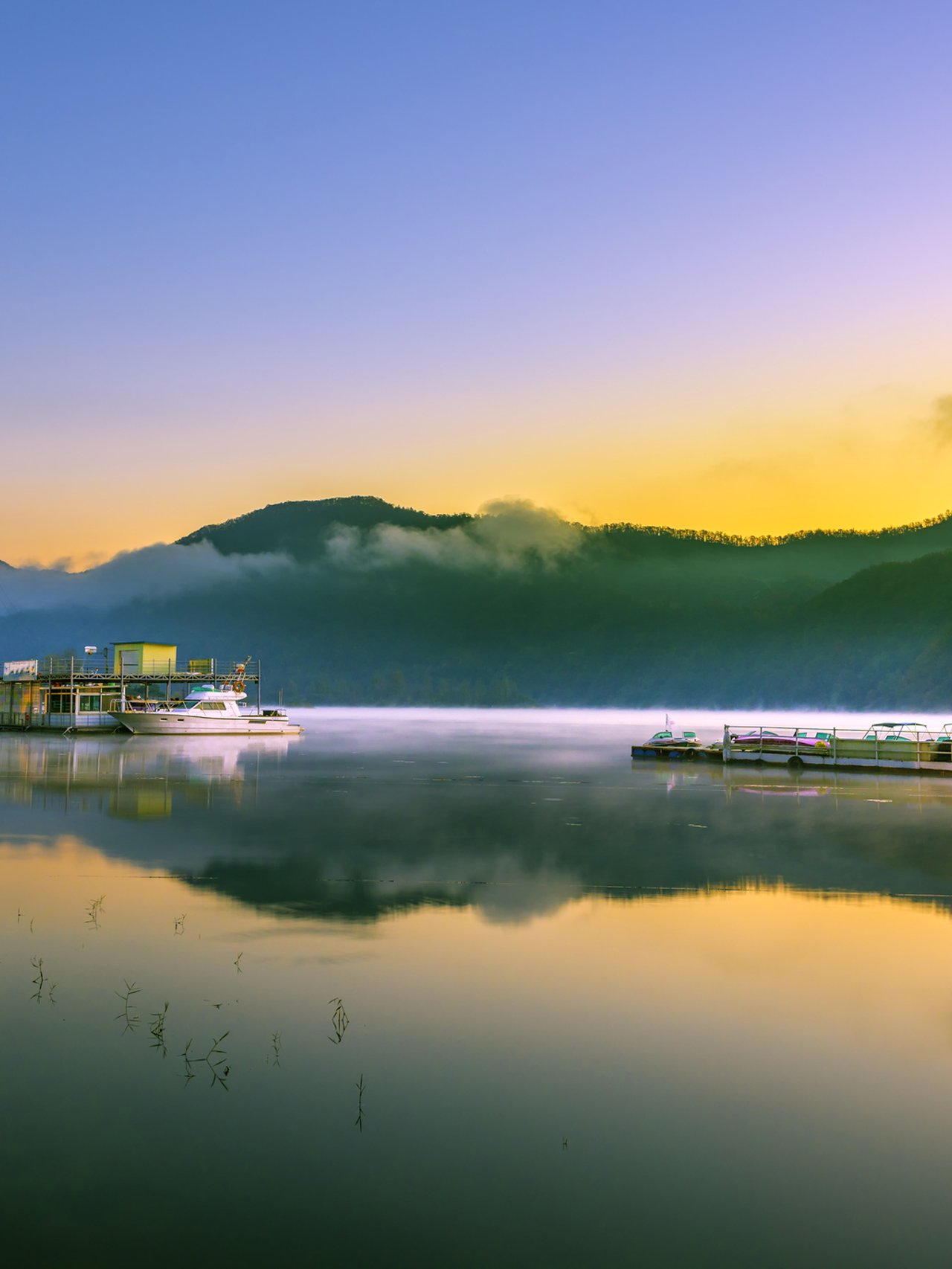 Reflections of the sky and boats in the river at Nami Island port, South Korea.
