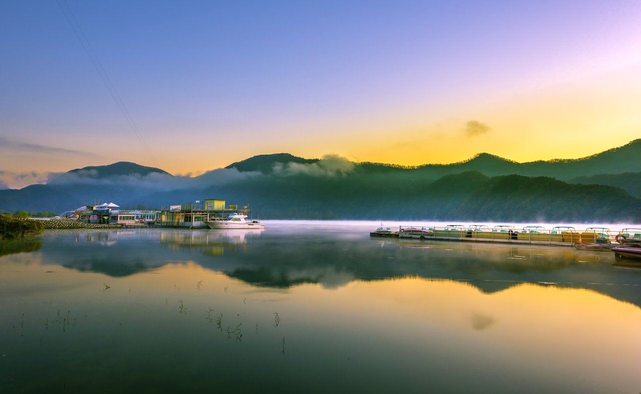 Reflections of the sky and boats in the river at Nami Island port, South Korea.