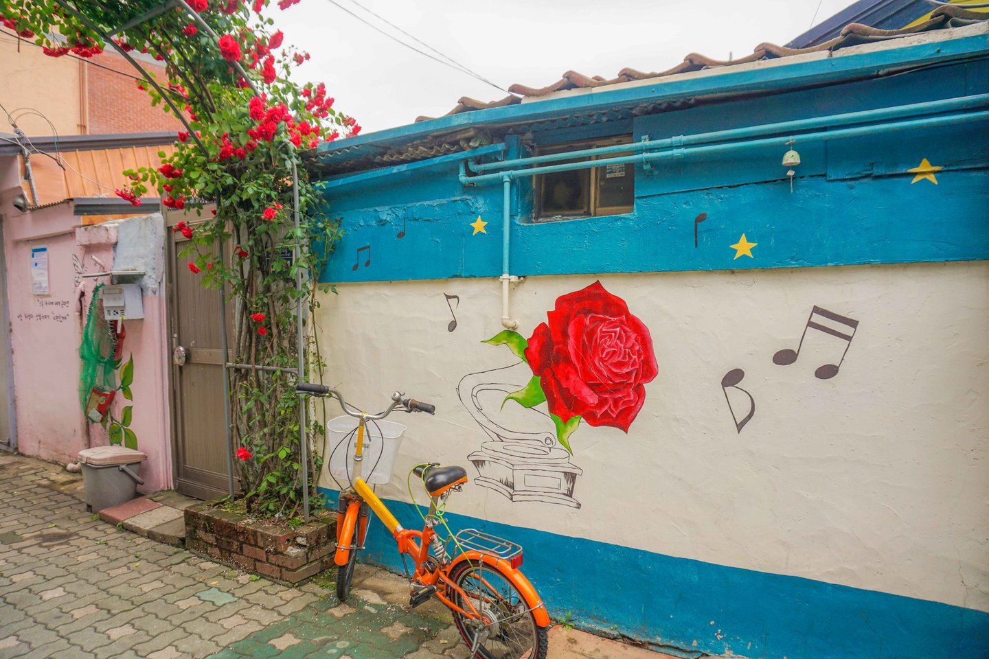 A bicycle next to a mural of a rose in Seoul, South Korea