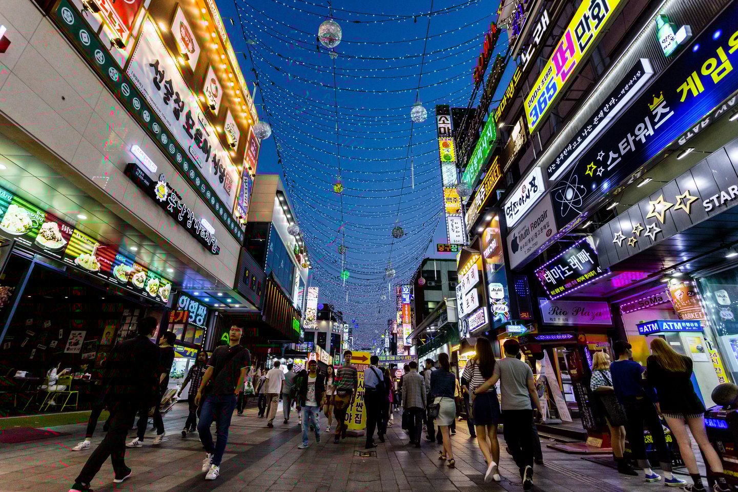 People walking down the main street of Suwon, South Korea at night