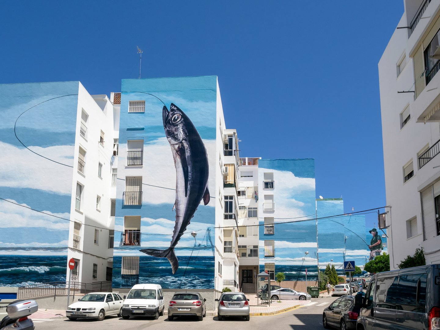 Fishing Day mural spanning several buildings in Estepona, Spain