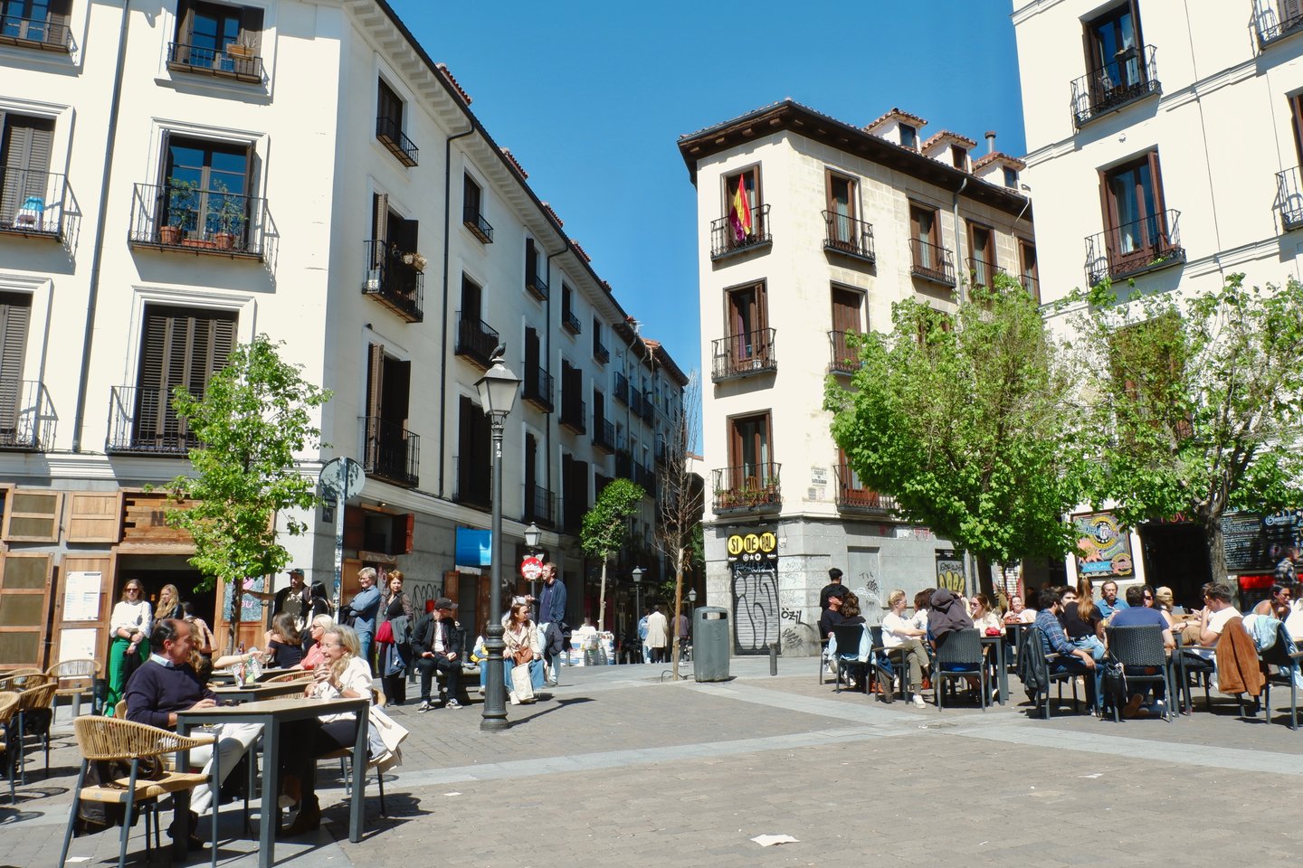 People eating outside on a sunny day in Malasaña, Madrid