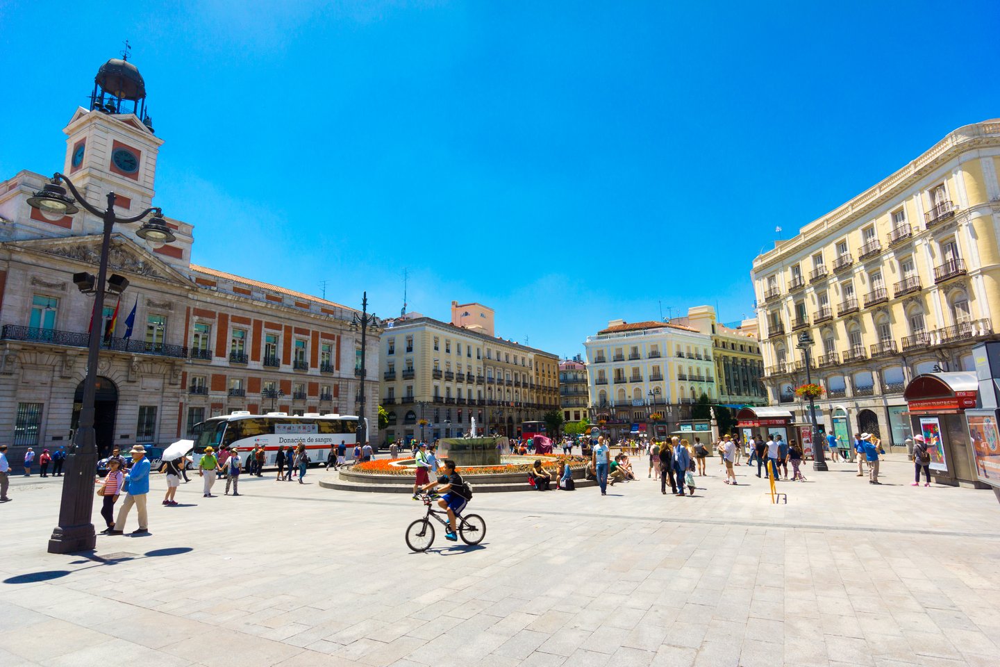 People visiting the famous Plaza Puerta del Sol in Madrid on a sunny day