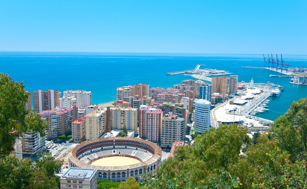 Malaga's bull ring with the harbour in the distance