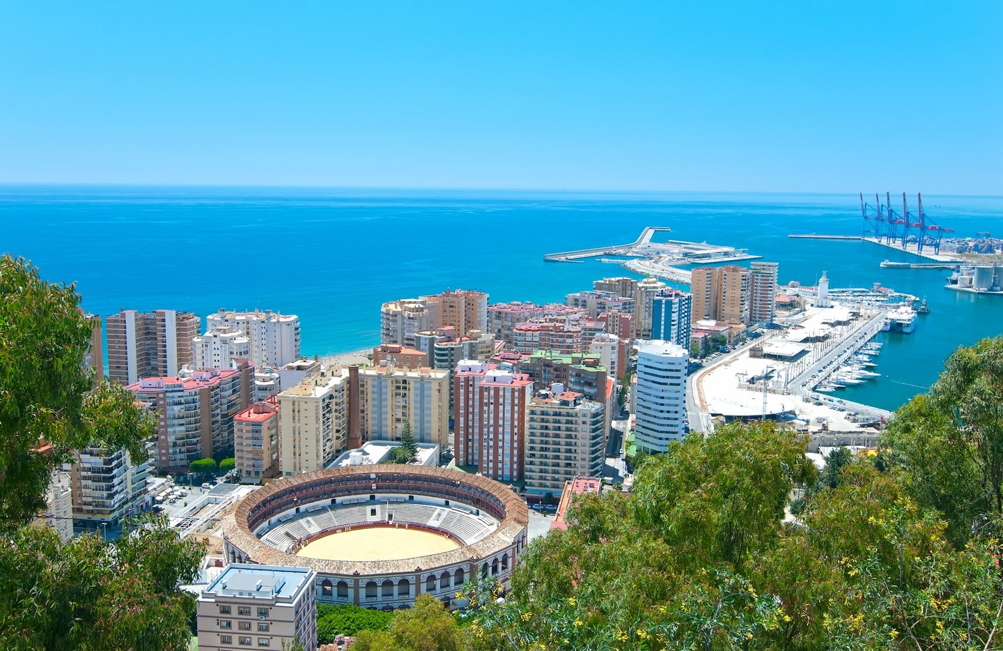 Malaga's bull ring with the harbour in the distance