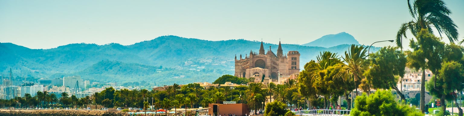 The beach in Palma de Mallorca with the cathedral in the distance