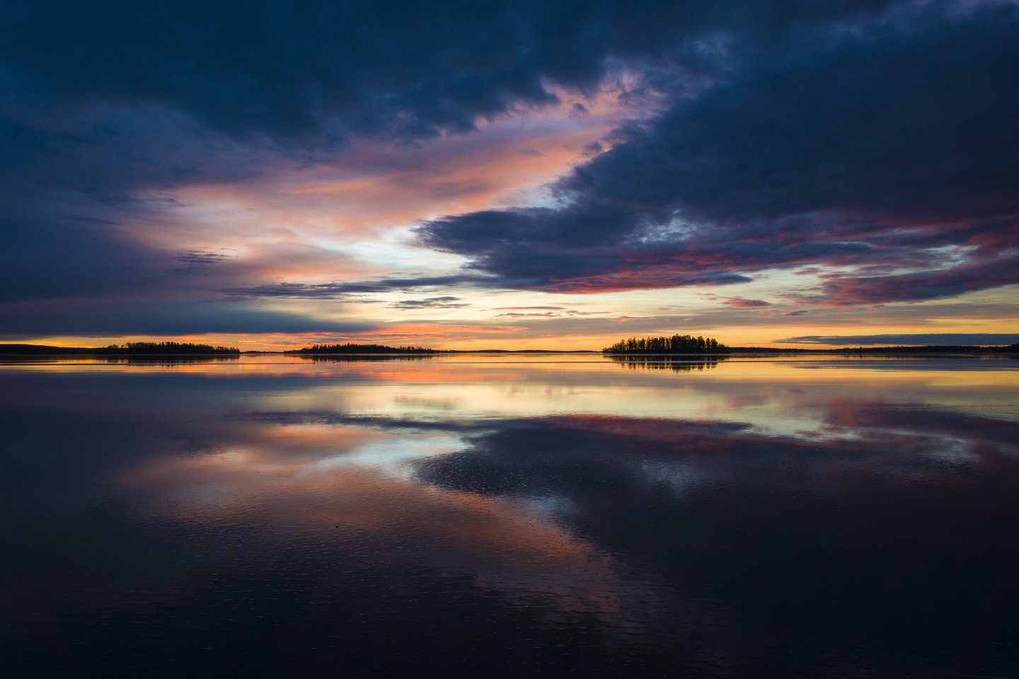 Colourful clouds reflected in the calm water of Lake Malaren