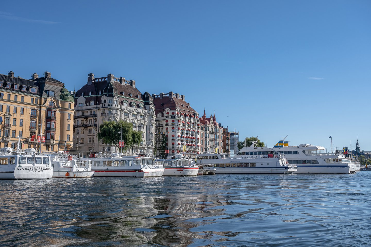 view of luxury yachts moored by the Ostermalm district on a sunny day.