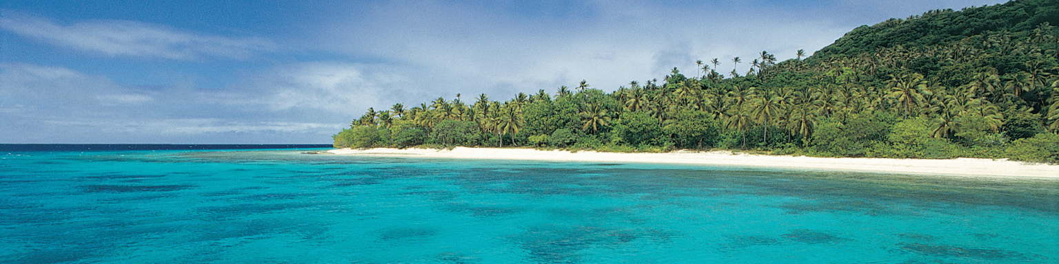 Clear, blue water with an island in the background on a sunny day