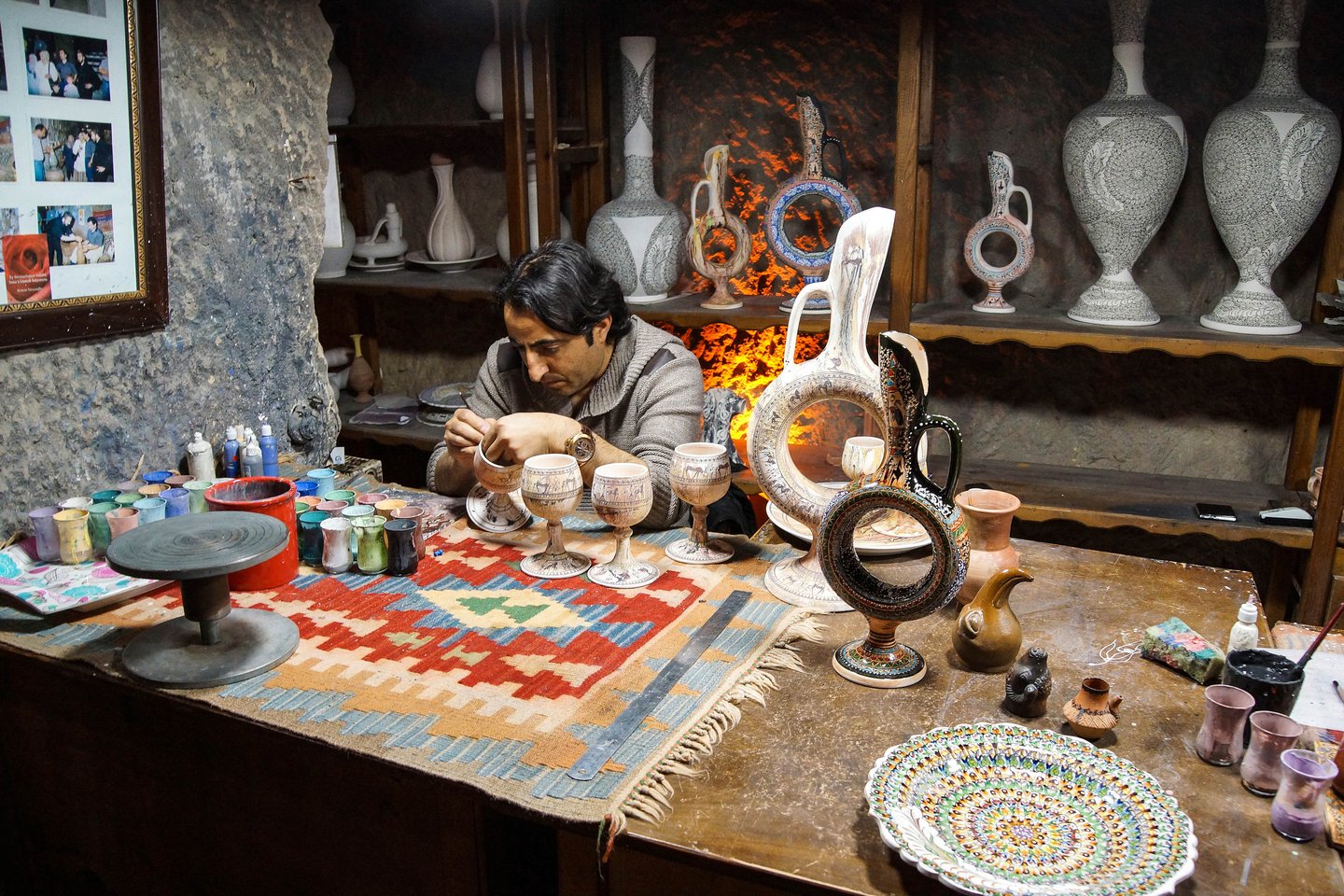 An artist paints unfired pottery in Avanos, Cappadocia