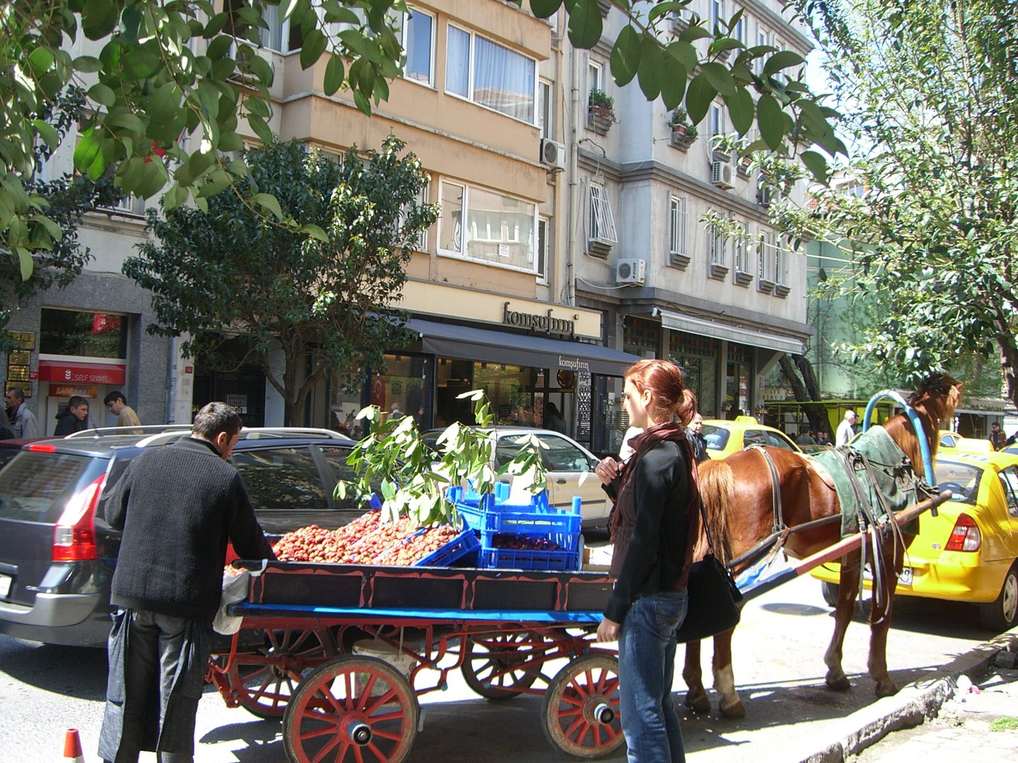 A woman buying strawberries from a cart in Cihangir