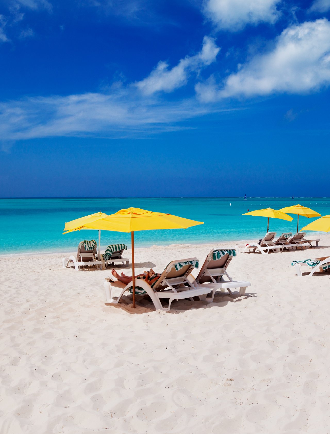 Colourful umbrellas and lounges on the white, sandy Grace Bay Beach in Turks and Caicos