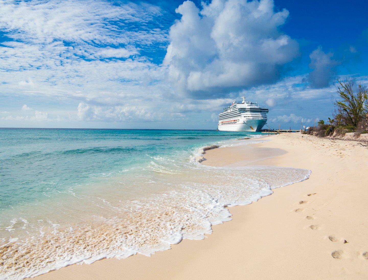 A white sandy beach on Grand Turk, with a cruise ship in the background