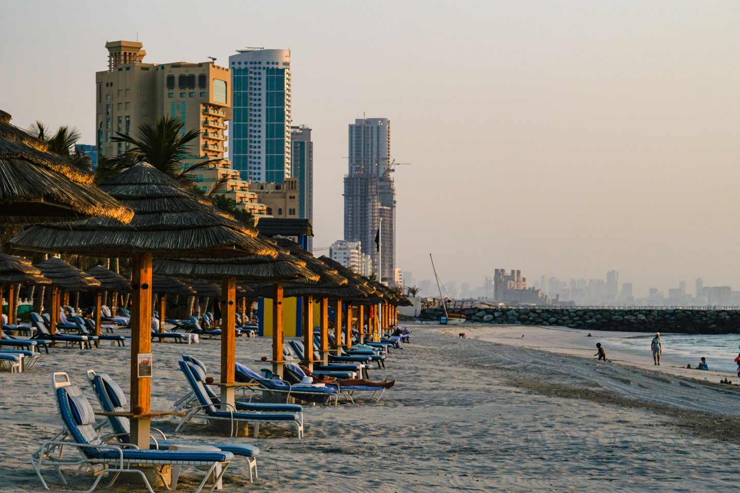 Sun umbrellas and loungers on the beach outside a hotel in Ajman, UAE.