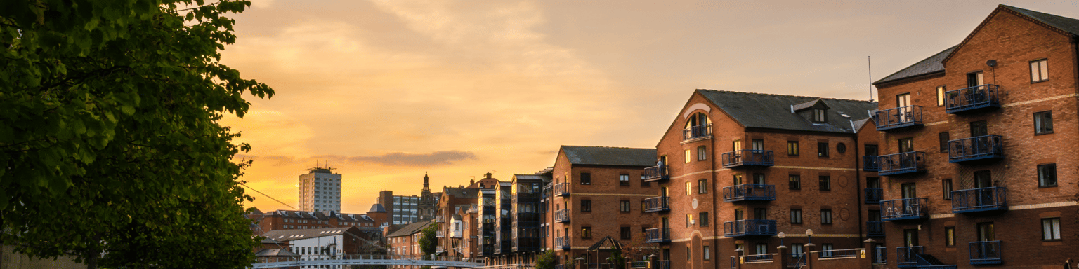 Redeveloped warehouses and modern bridge on the River Aire in Leeds at sunset