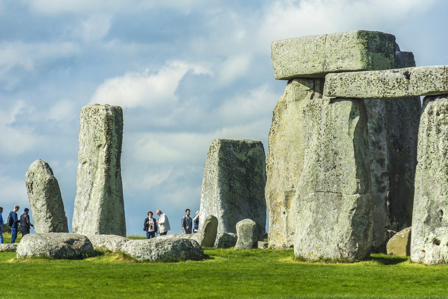 Visitors looking tiny next to the huge stones at Stonehenge