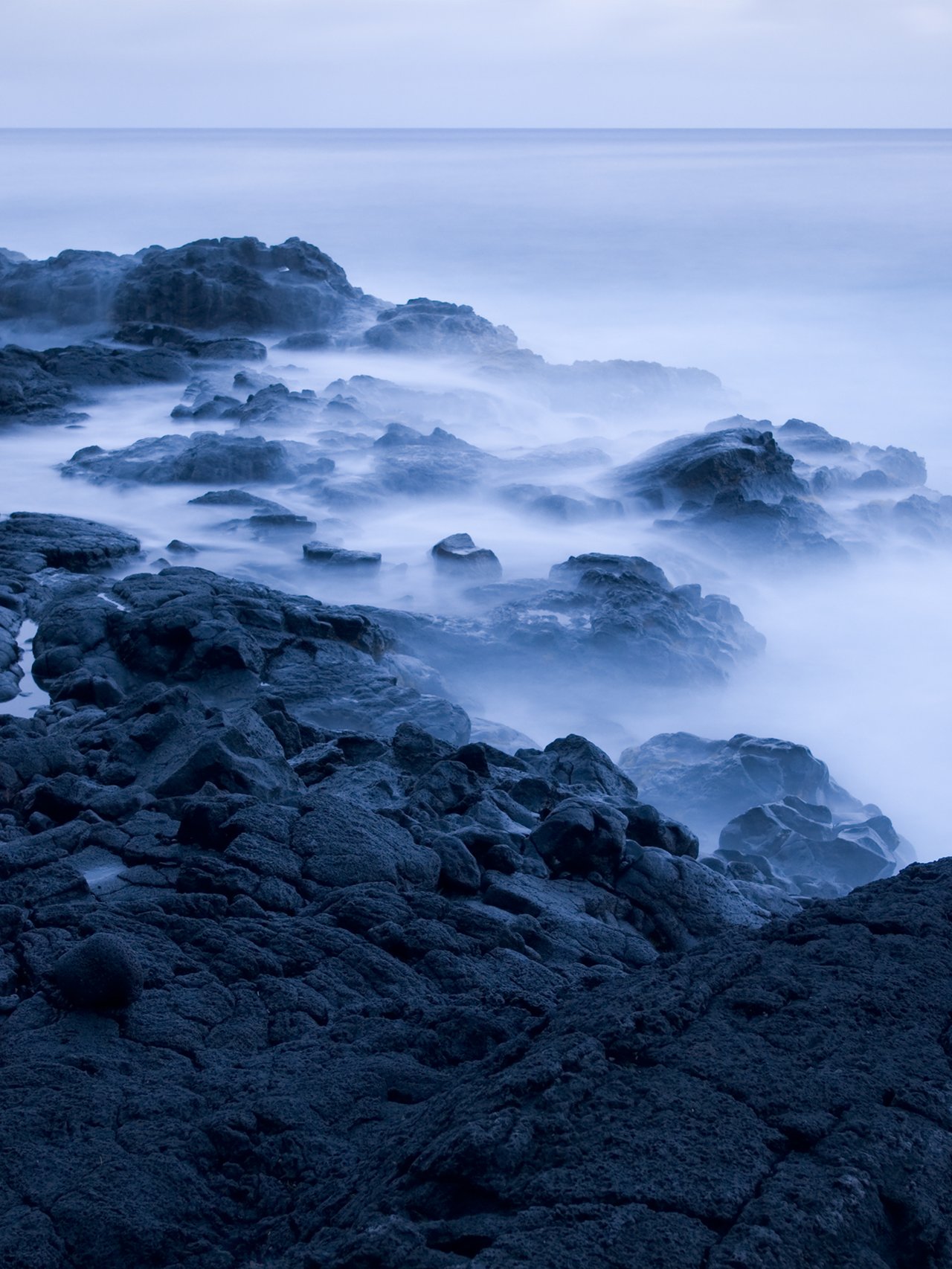 Waves crashing on lava rocks on the Big Island, Hawaii.