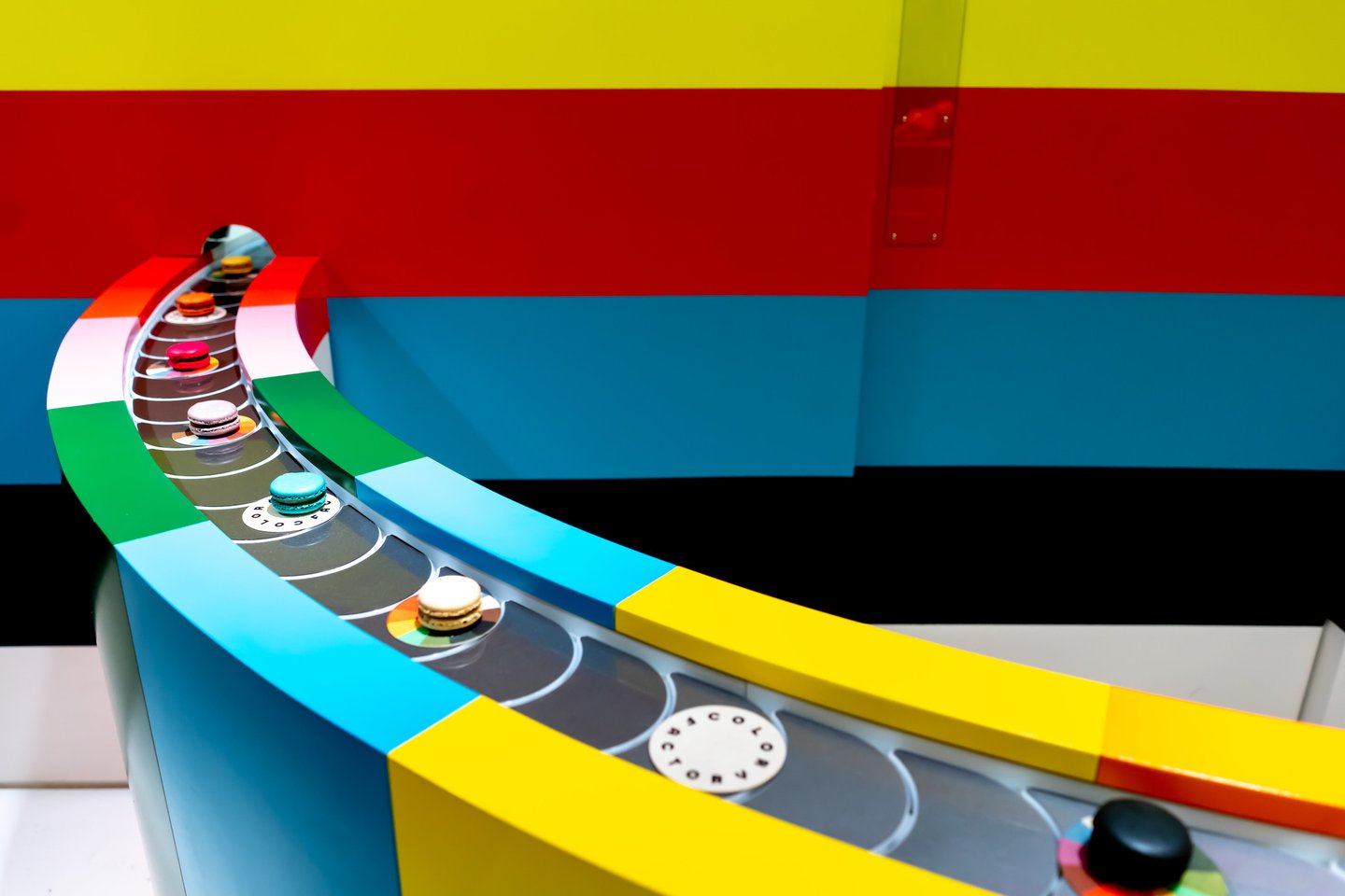 Colourful macarons on a conveyor belt at the Color Factory